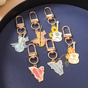 Porte-clés en émail en forme d'instruments de musique avec motifs de fleurs et guitare