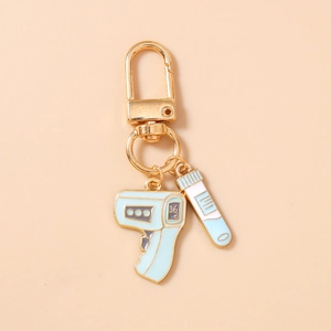 Detail of medical keychain with blue infrared thermometer and test tube enamel pendants