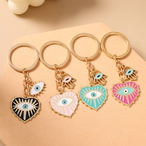 Lot de quatre porte-clés dorés avec breloques cœur mauvais œil et main de Fatma colorées