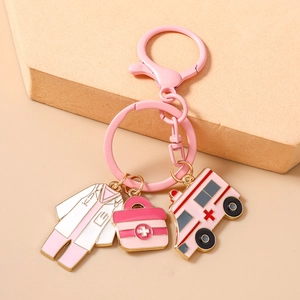 Close-up of a pink medical-themed keychain with nurse outfit and ambulance charms