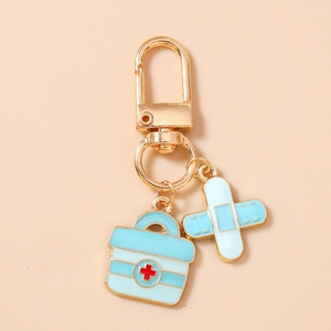 Detail of medical keychain featuring gold lobster clasp with blue first aid kit and bandage charms