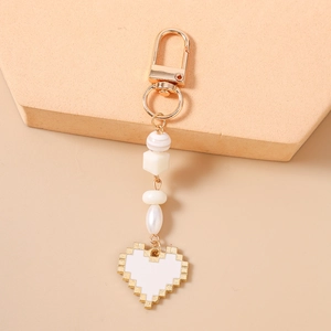 Detail of 8-bit pixel heart keychain with gold lobster clasp and white beads