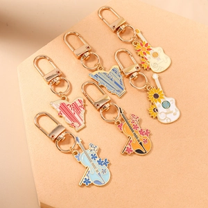 Porte-clés instruments de musique avec guitare, violon et motifs de tournesols en émail