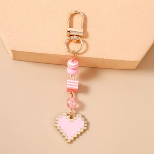 Detailed view of pink pixel heart keychain with gold clasp and decorative beads