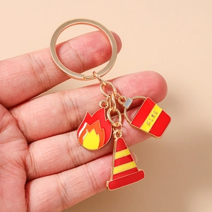 Detail of firefighter keychain with flame, fire bucket and traffic cone metal charms