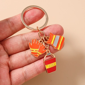 Detailed view of firefighter enamel keychain featuring gold charms on a metal ring