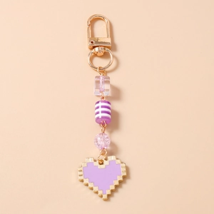Close-up of pixel heart keychain with purple beads and golden lobster clasp detail