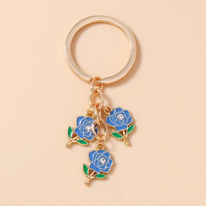 Detailed view of blue enamel roses with rhinestones on a gold-tone flower keychain