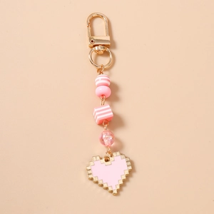 Close-up of pink pixel heart keychain with striped beads and golden metal clasp hanging