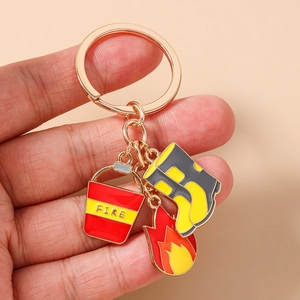 Detail of firefighter keychain with fire flame, bucket, and boot charms held in hand