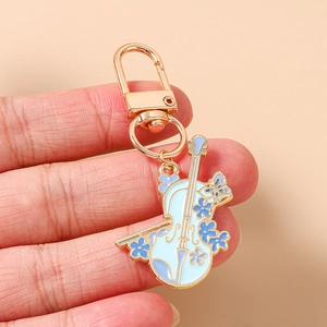 Vue macro d'un porte-clés violon doré avec des détails de fleurs en émail bleu