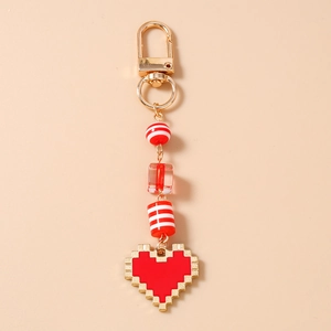 Detail of pixel art heart keychain with golden alloy ring and striped colorful beads
