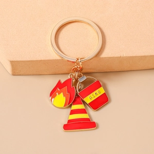 Detail of firefighter keychain with red flame, traffic cone, and water bucket charms