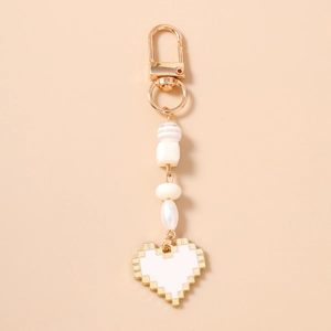 Detail of pixel heart keychain featuring white beads, gold hardware, and a lobster clasp