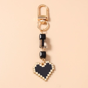 Macro detail of pixel heart keychain with gold clasp and acrylic beads in retro style