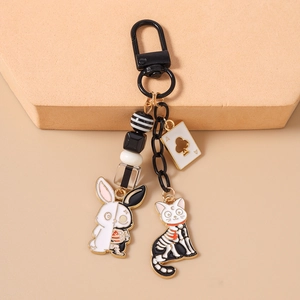 Detail of gothic animal keychains with enamel rabbit, skeleton cat and ace card