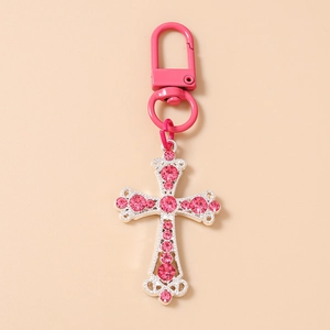 Détail du porte-clés croix orné de strass roses avec mousqueton fer à cheval assorti