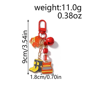 Detail view of firefighter keychain with red bell and orange glove charms on metal ring
