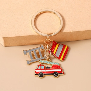 Detail view of firefighter keychain charms featuring fire truck and suit with gold ring