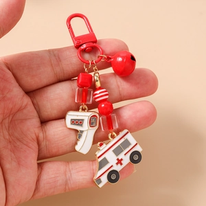 Detail of red beaded medical keychain with ambulance and thermometer charms and bell