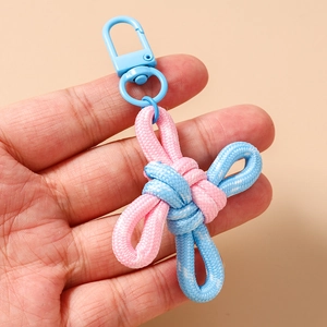 Detail of pink and blue hand-woven cross knot keychain with blue plastic lobster clasp