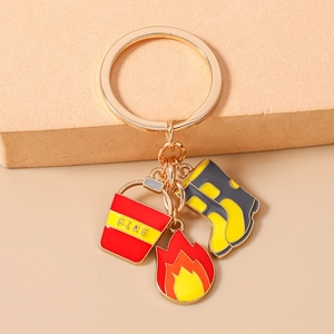 Detail of firefighter keychain with gold rings, fire bucket, flame, and boot charms