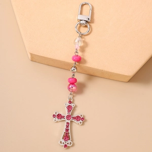 Détail du porte-clés perlé avec pendentif croix en strass roses et fermoir métallique solide