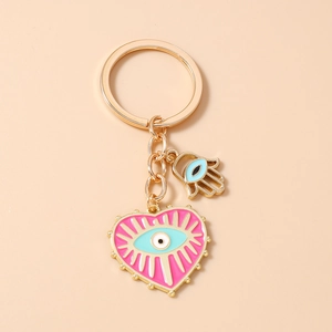 Détail du porte-clés cœur rose avec œil en émail et pendentif main de fatma