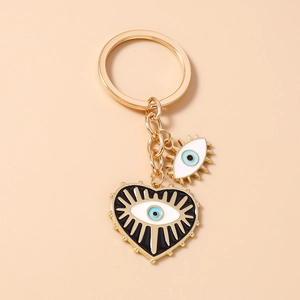 Détail d'un porte-clés coeur oeil bleu en métal doré avec finition émail brillante