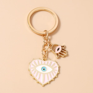 Détail du porte-clés cœur rose avec émail œil bleu et breloque main de fatma