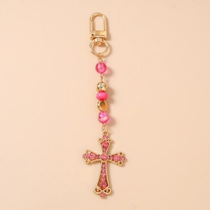 Détail du porte-clés à perles roses avec croix en strass et fermoir mousqueton doré