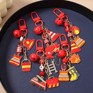 Firefighter themed keychain set with red hydrant, truck and helmet charms on blue tray