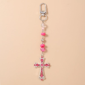 Détail du pendentif croix en strass rose et porte-clés perlé avec fermoir en argent