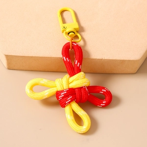Macro detail of red and yellow braided rope keychain with yellow metal hook