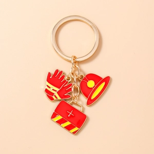 Detail of firefighter keychain with gold ring and enamel glove, helmet, and first aid bag