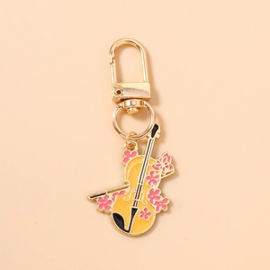 Détail du porte-clés violon jaune avec fleurs de cerisier et finitions dorées brillantes