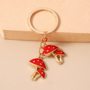 Detailed close-up of golden mushroom keychain with red polka dot charms on a warm background