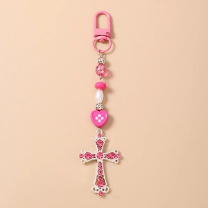 Détail d'un porte-clés à perles roses avec croix en strass scintillante et perle cœur