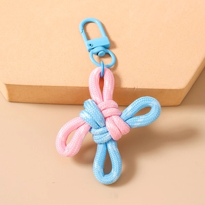 Macro detail of handmade pink and blue woven knot keychain with a blue spring buckle