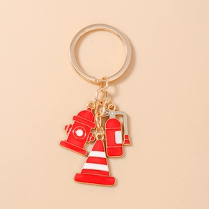 Detailed view of red enamel fire hydrant, extinguisher and cone charms on golden keychain