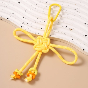 Detail of yellow Chinese knot keychain with aluminum carabiner and vibrant woven cord
