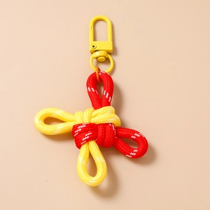 Detail of handcrafted Chinese knot keychain with red and yellow woven rope and clasp