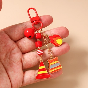 Detail of firefighter keychain set with red lobster clasp, bells, and enamel charms