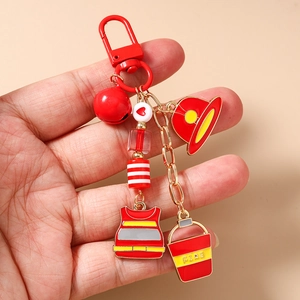 Detailed macro view of firefighter keychain with red fire hat and bucket charms