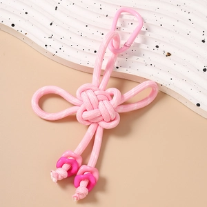 Detailed close-up of pink woven Chinese knot keychain with matching carabiner and geometric beads