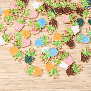 Flat lay of colorful enamel potted plant charms with metal rings for DIY jewelry making