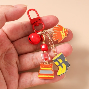 Detail of firefighter keychain with reflective vest, glove, and boots charms