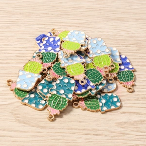 Détail macro de pendentifs cactus en émail coloré avec fleurs pour création de bijoux DIY