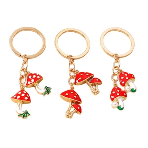Three-piece mushroom keychain set with red enamel, gold alloy finish, and white pearls