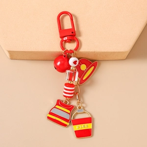 Detail of firefighter keychain with red helmet, vest, fire bucket and bell charms